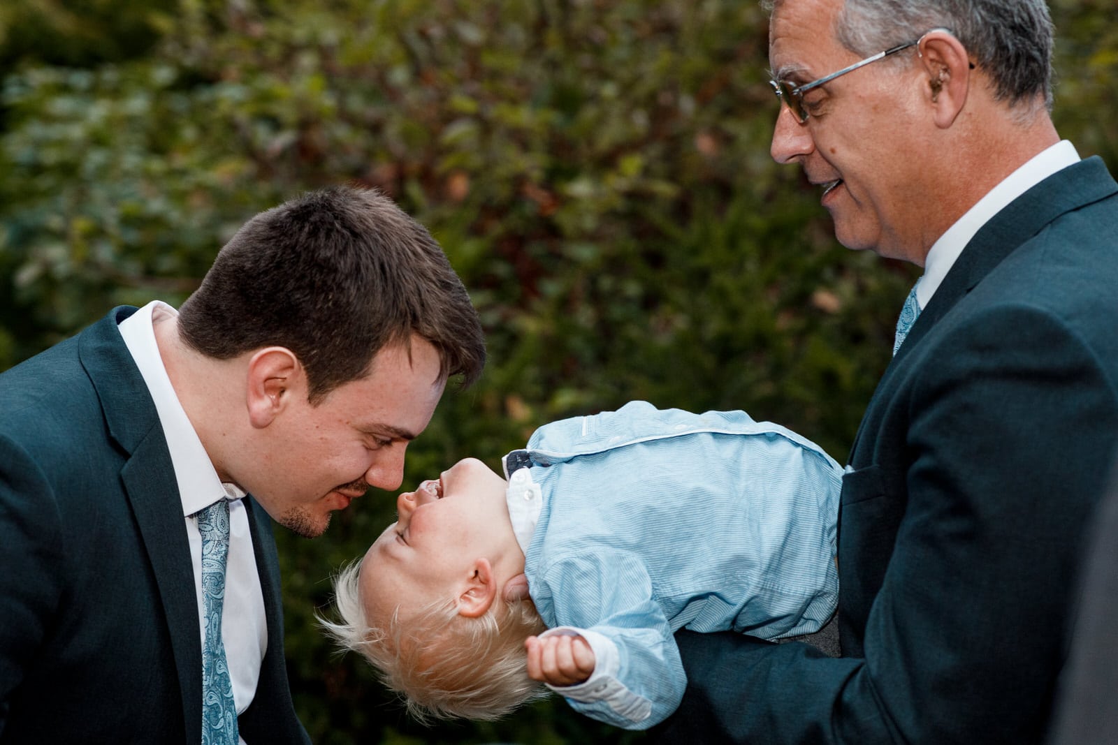 kid being kissed by father at wedding day 