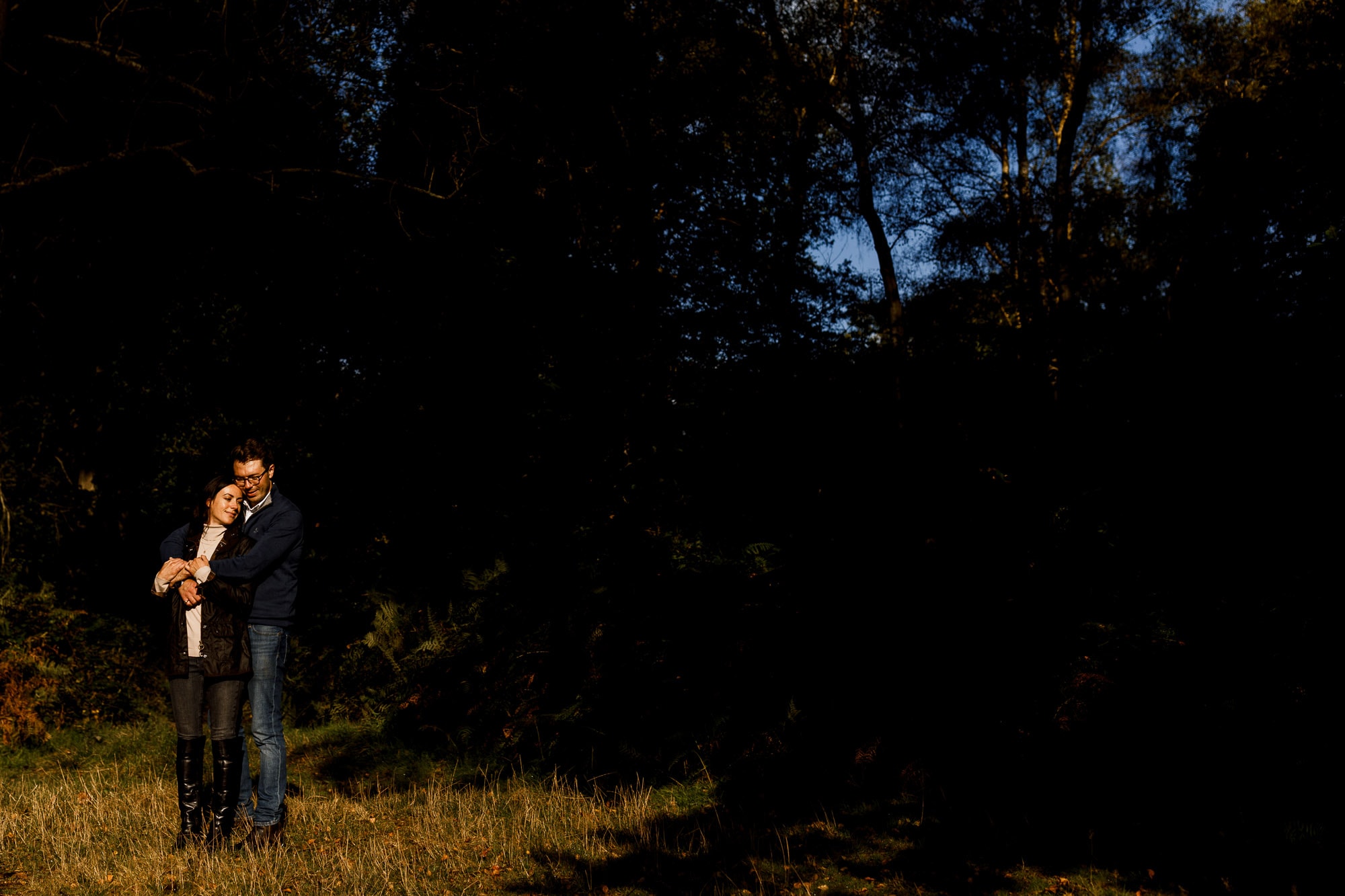 couple posing in sunlight for engagement shoot at ashridge house
